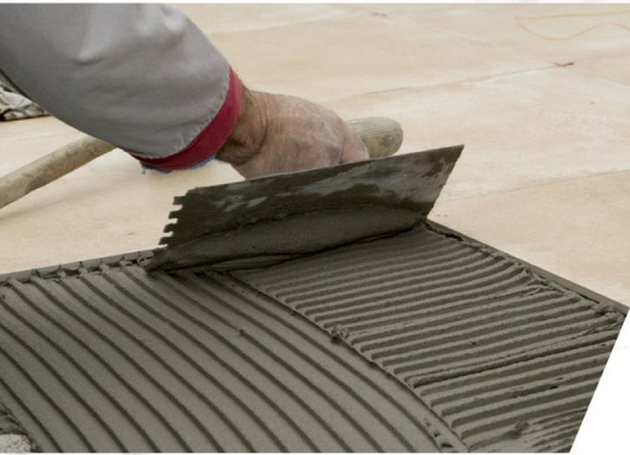 Tile adhesive being applied with a notched trowel
